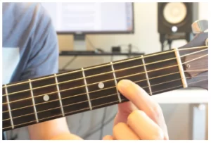 How much finger pressure is needed when playing the guitar?