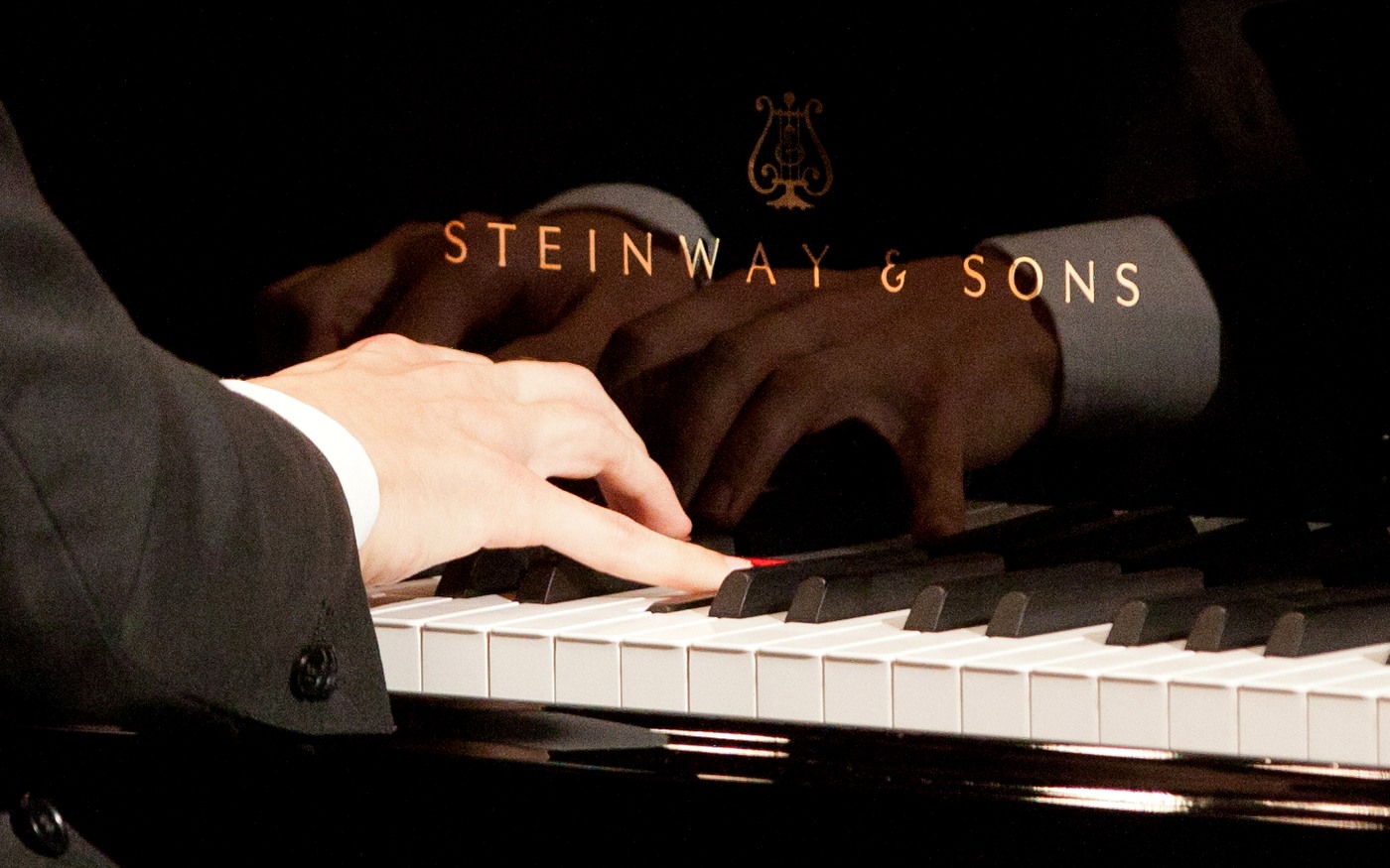 Connected Piano Legato Touch Close-up of hands demonstrating connected piano legato technique on a grand piano