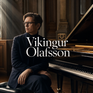 Vikingur Olafsson beside a concert grand piano in an elegant London hall
